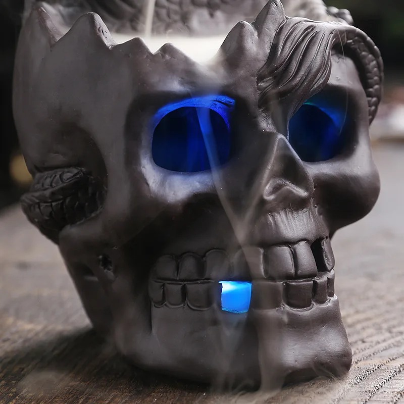 Détail du crâne du brûleur d'encens à reflux LED avec lumière bleue et fumée en cascade