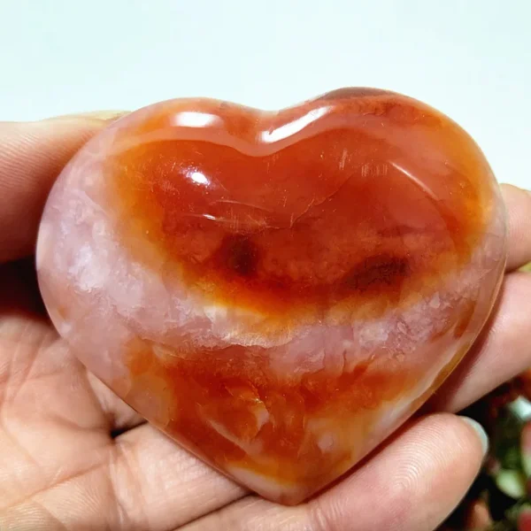 Cœur en agate rouge et blanc naturelle, pierre d'harmonie et de bien-être, nuances de rouge profond et blanc cristallin, tenu en main