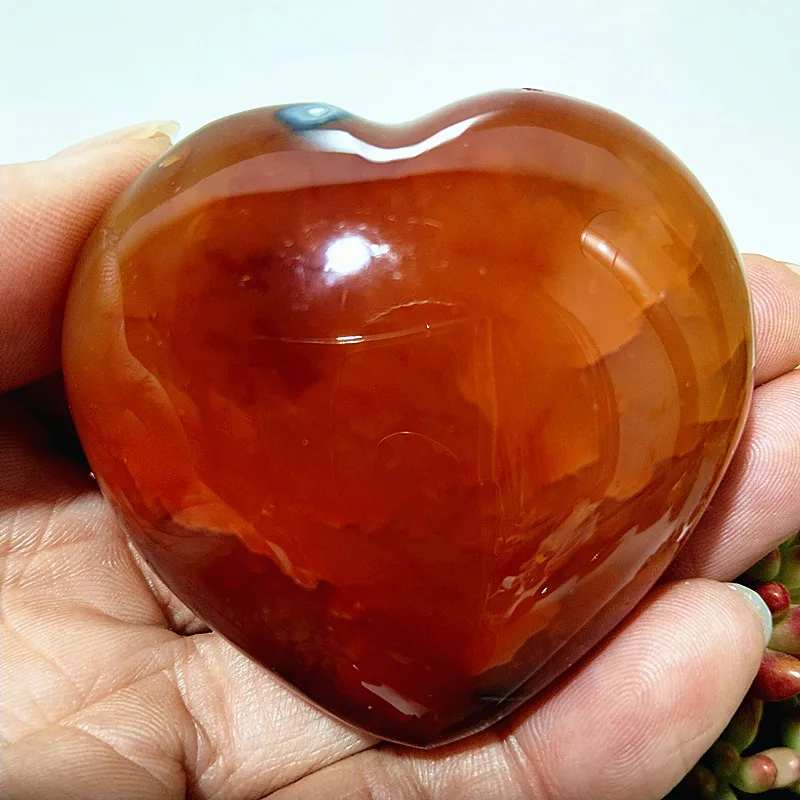 coeur-agate-rouge-naturelle-calme-harmonie Cœur en agate rouge naturelle, pierre de calme et d'harmonie, nuances chaleureuses de rouge et orange, tenu en main