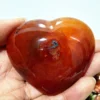 coeur-agate-rouge-naturelle-inclusion-unique-bien-etre Cœur en agate rouge naturelle avec inclusion, symbole de bien-être et de vitalité, tenu en main