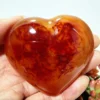 coeur-agate-rouge-naturelle-motifs-organiques-bien-etre Cœur en agate rouge naturelle avec motifs organiques, symbole de bien-être et d'énergie positive, tenu en main