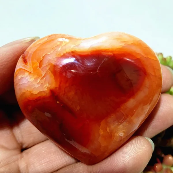 Cœur en agate rouge et orange naturelle, pierre pour des vibrations positives et l'équilibre énergétique, tenu en main