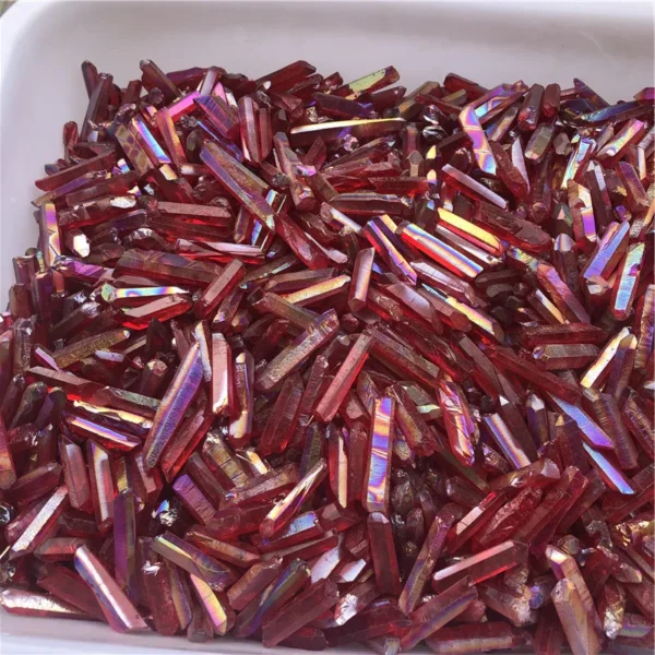 Gros plan sur des cristaux de quartz lémurien Aura Arc-en-Ciel Rouge en vrac dans un plateau, parfaits pour la guérison et la décoration.