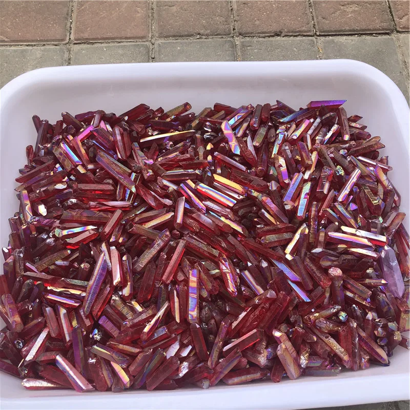 cristaux-quartz-lemurien-aura-arc-en-ciel-rouge-vrac-titane-guérison Cristaux de quartz lémurien Aura Arc-en-Ciel Rouge en vrac, plaqués titane, dans un plateau blanc pour guérison et décoration.