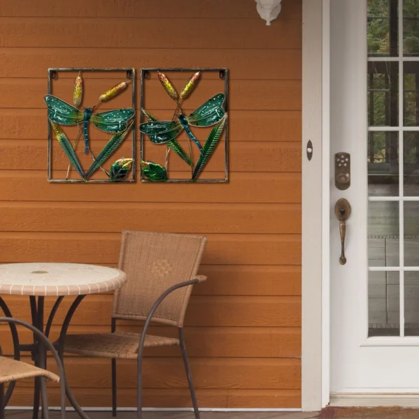Décoration murale en forme de libellule en métal et verre, installée sur une terrasse extérieure en bois