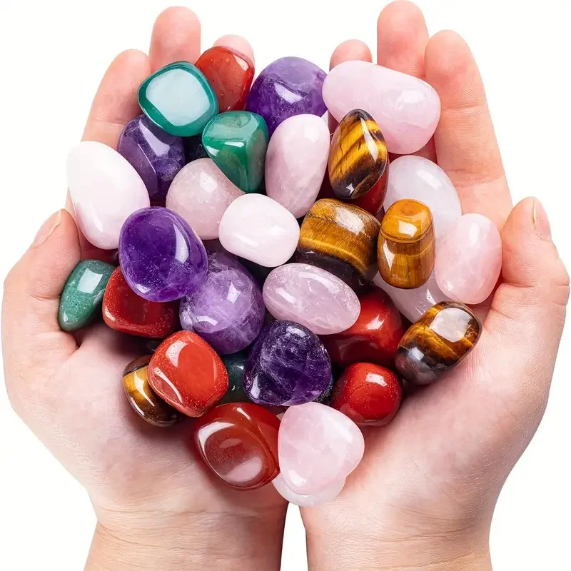 ornements-pierres-cristal-polies-multicolores-main-bijoux-deco Ornements en pierres de cristal polies multicolores tenus dans les mains, comprenant quartz rose, améthyste, aventurine verte, jaspe rouge et œil de tigre