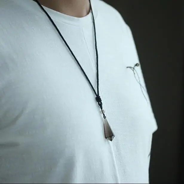 pendentif-quartz-fume-naturel-porte Pendentif en quartz fumé naturel en forme de pointe longue, porté sur un t-shirt blanc.