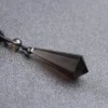 Pendentif en quartz fumé naturel en forme de pointe avec cordon noir, symbole de protection.