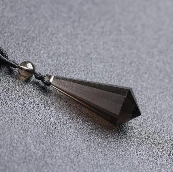 Pendentif en quartz fumé naturel en forme de pointe avec cordon noir, symbole de protection.
