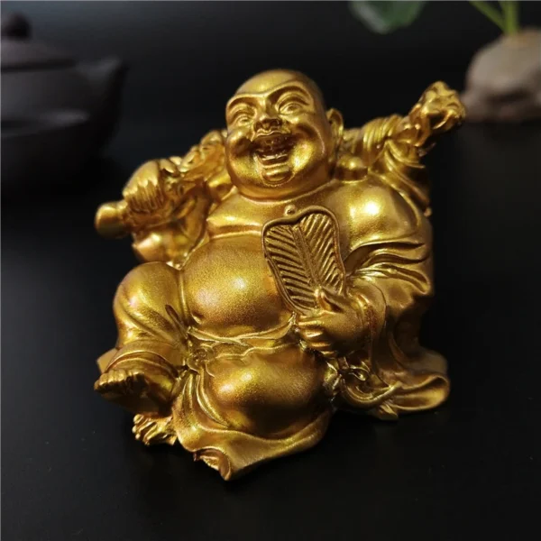 Gros plan de la statue de Bouddha Rieur Maitreya en résine dorée, symbolisant chance et prospérité.