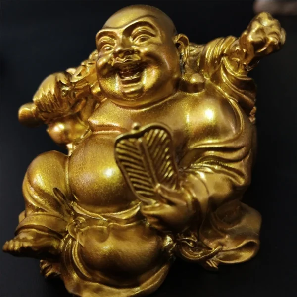 Gros plan de la statue de Bouddha Rieur Maitreya en résine dorée, montrant un visage joyeux et des détails fins.