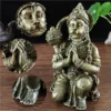 Détails en gros plan de la statue en résine couleur bronze de Hanuman, montrant le visage, les mains en prière et les ornements.